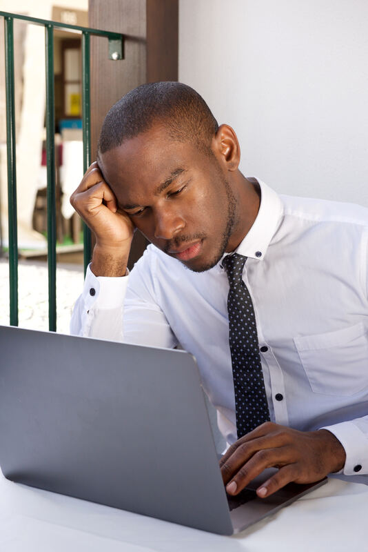 A person in quiet thought, working at a desk by a window