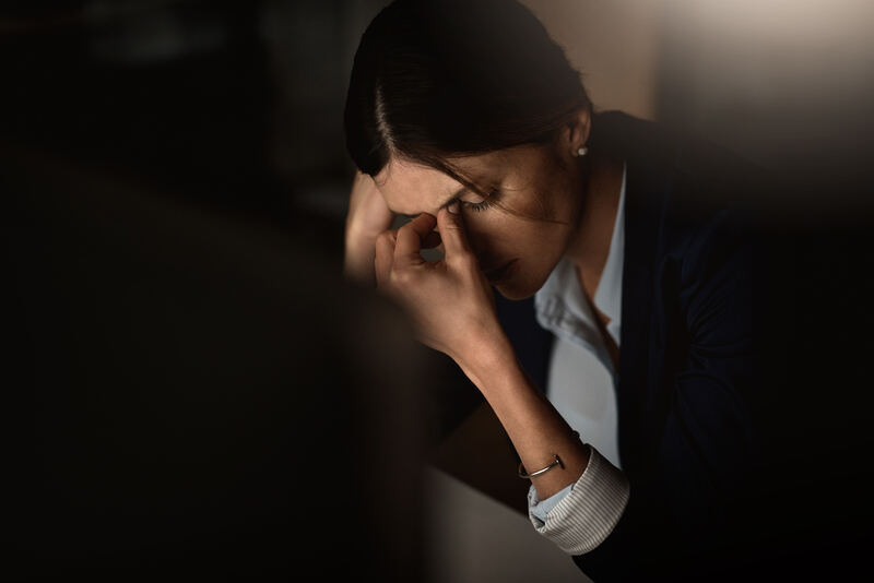 A woman at a desk looking worn down